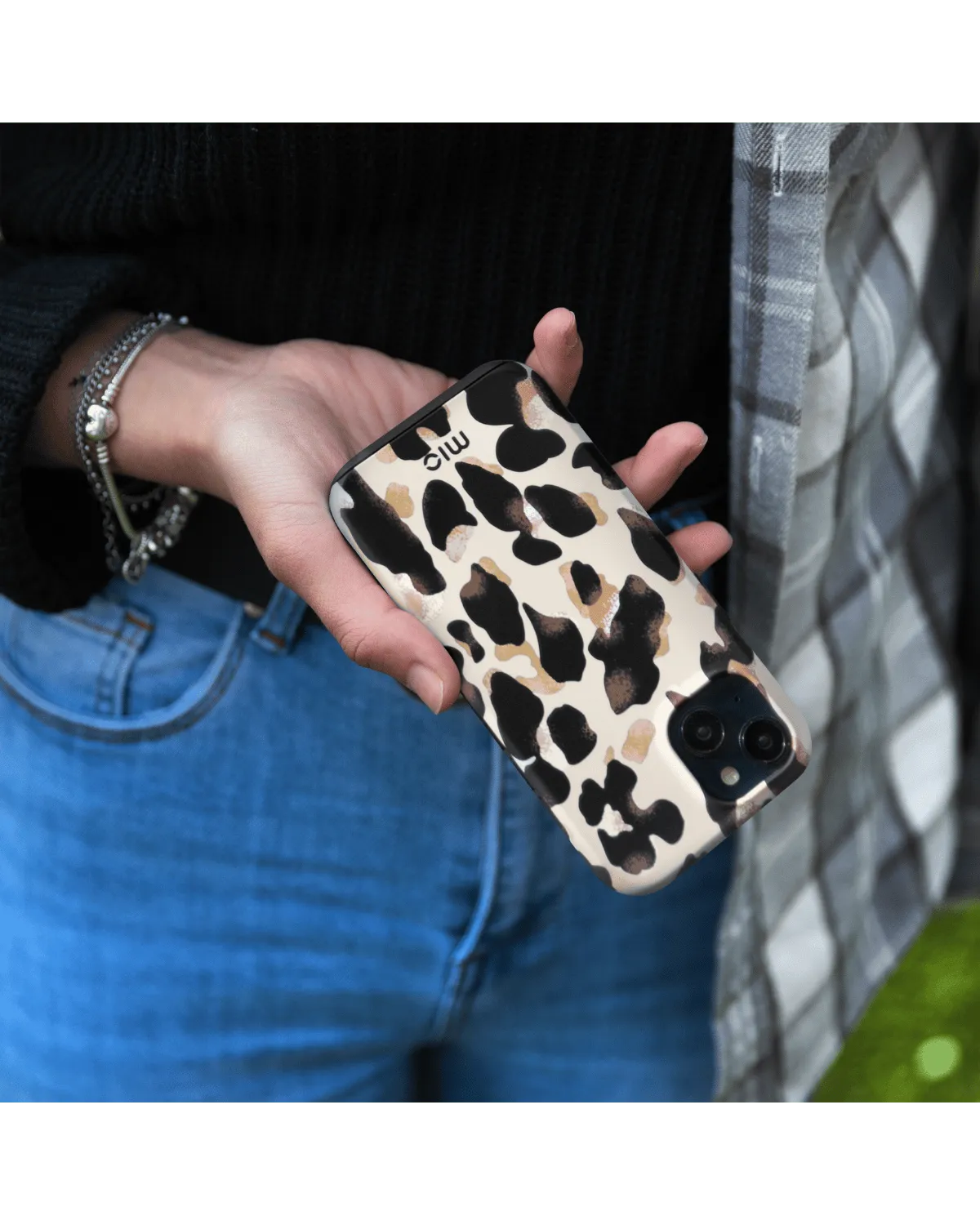 Hand met Samsung Galaxy A55 in Mio Leopard hoesje met glanzende panterprint.
