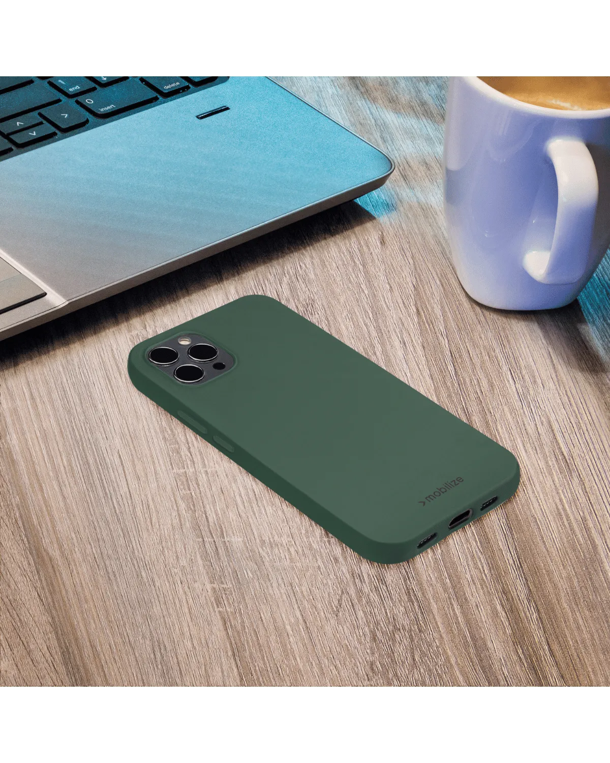 Mat groene Mobilize Gelly Case op een houten tafel naast een laptop en koffiekop, stijlvol en functioneel ontwerp.